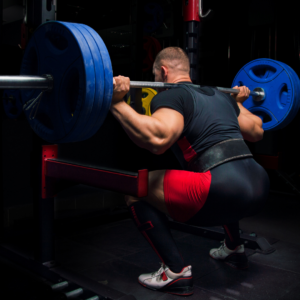 man squatting heavy weight from rear